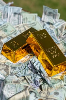 Two gold bars rest on a pile of US dollar bills, symbolizing wealth and prosperity.